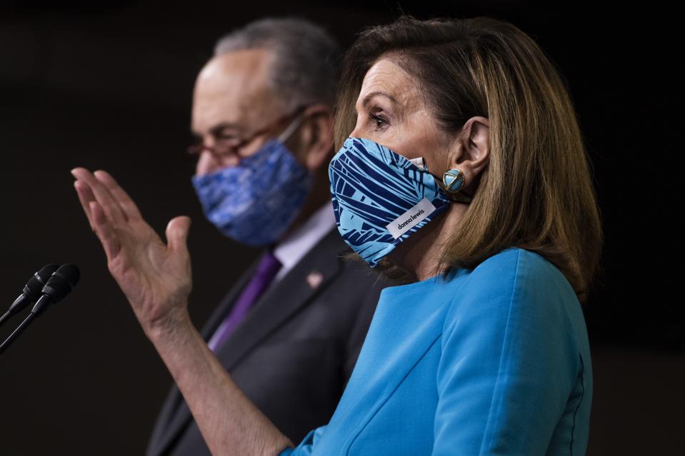 Schumer and Pelosi wearing masks in front of a microphone