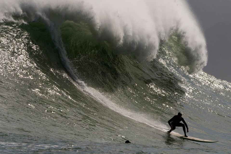 Large wave crashing just behind surfer