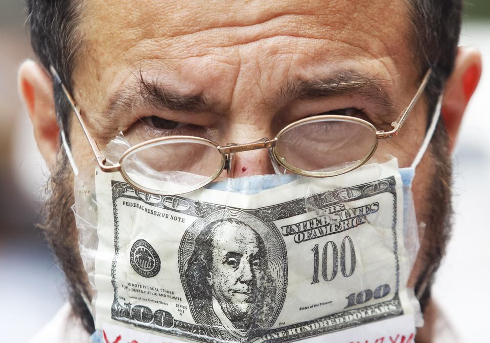 Un hombre con una máscara facial con estampado de dólares estadounidenses como ...