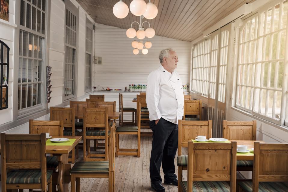 Restaurant owner standing in his empty restaurant.