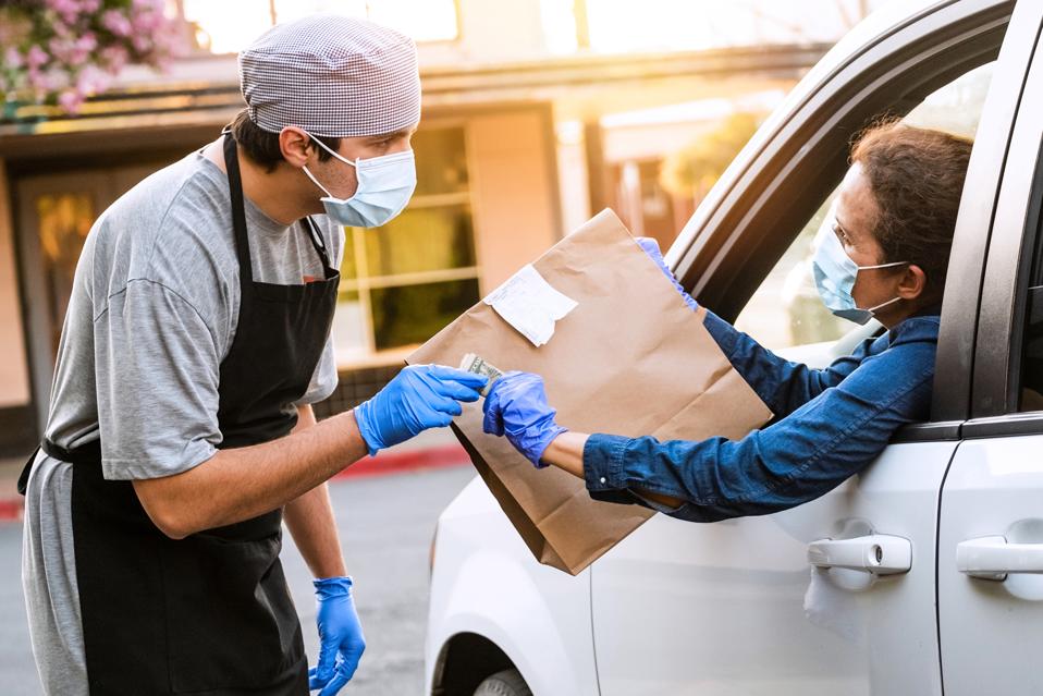 Woman picking her restaurant food from her car at a Curbside pickup