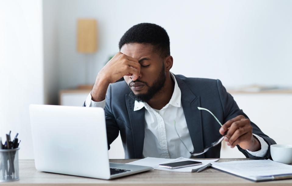 Stressed businessman working at desk.
