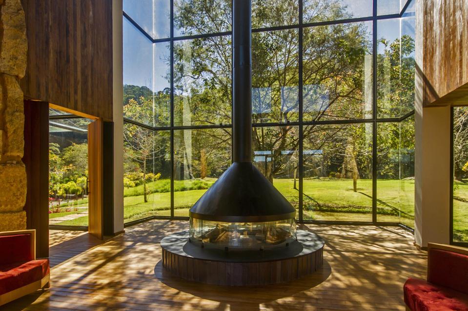 A large fireplace dominates the lobby of the Six Senses Botanique hotel in Brazil