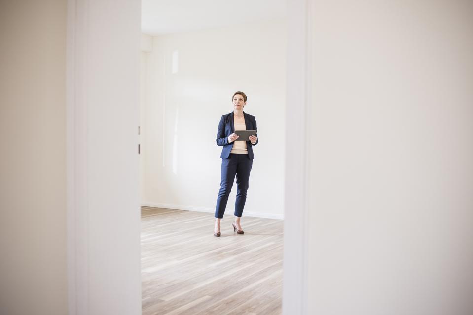 Woman in empty apartment with tablet