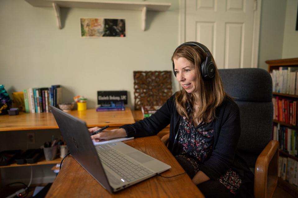 counselor sits at laptop computer