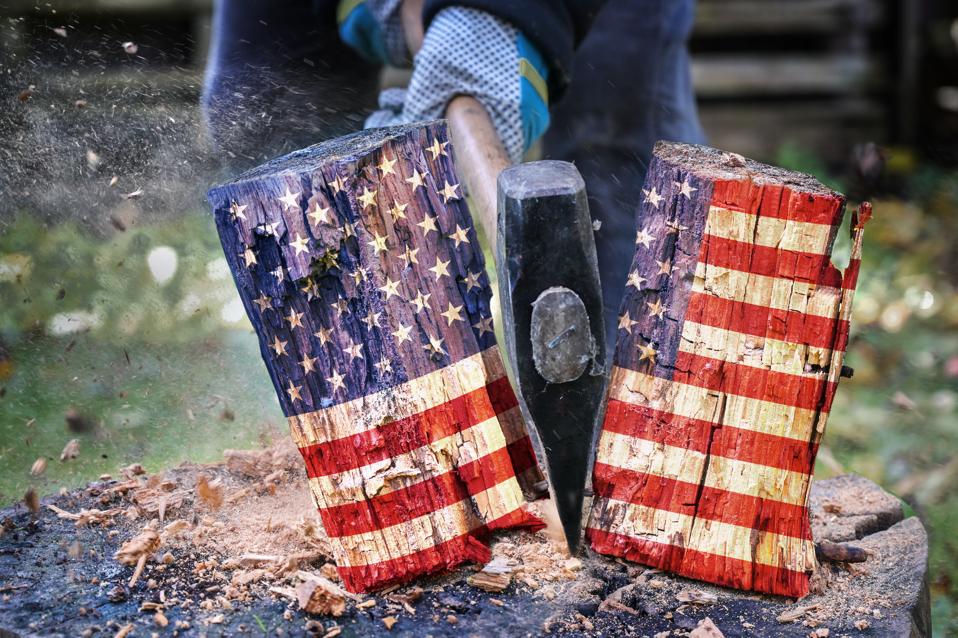 Wooden block with American flag is split in two halves with an axe, metaphor for the divided country after the election