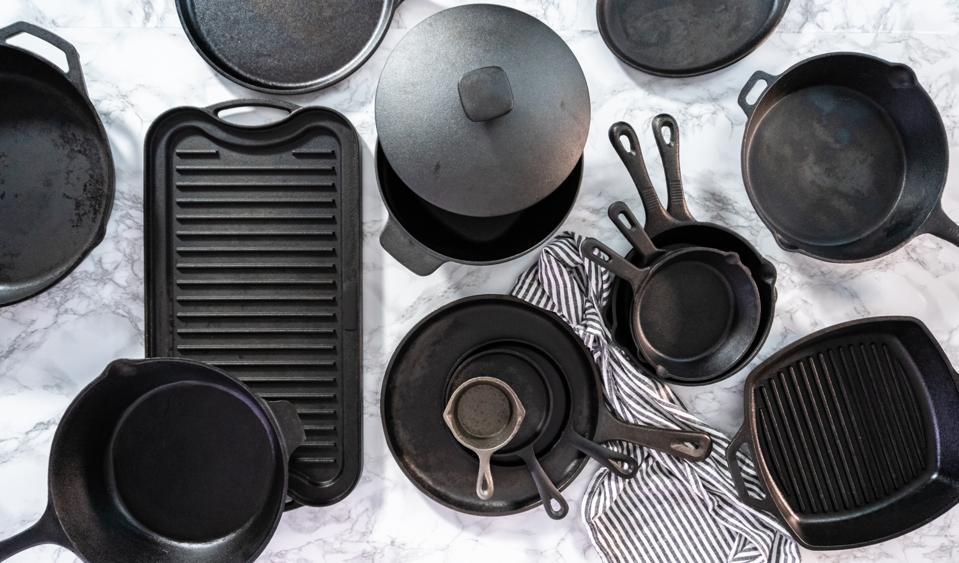 Variety of cast iron frying pans on a marble background.