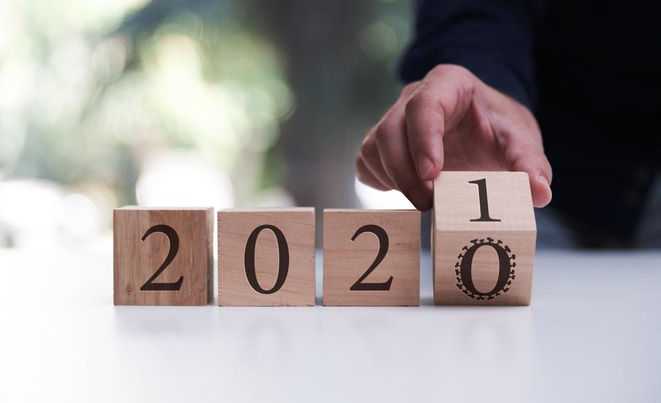 Businessman flipping over block for 2020 to 2021. Business, new year and Covid-19 Concept.