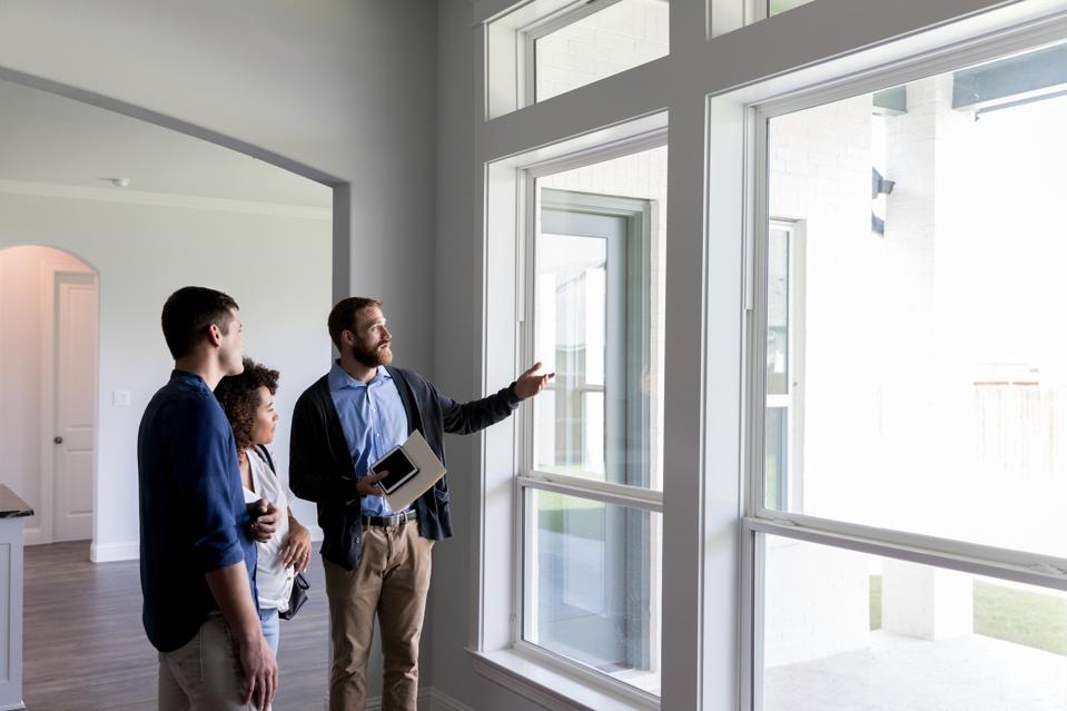 Male realtor shows a couple a beautiful home