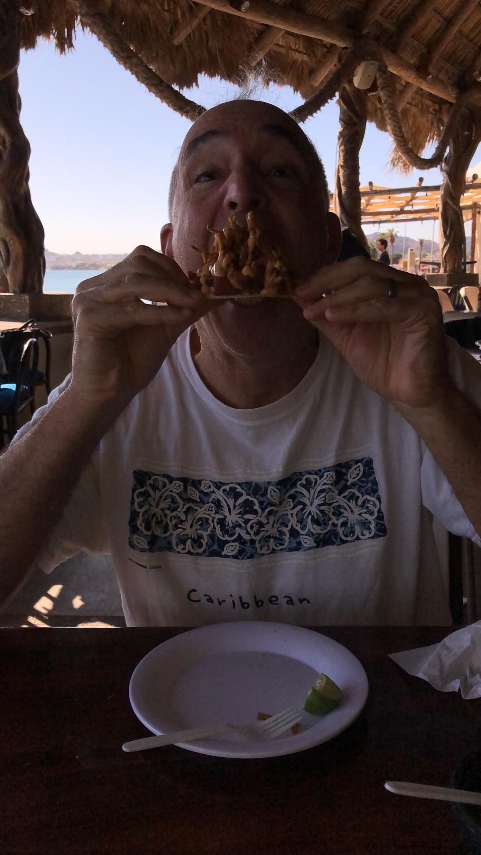 Author indulging in seafood tostada in Mexico restaurant.
