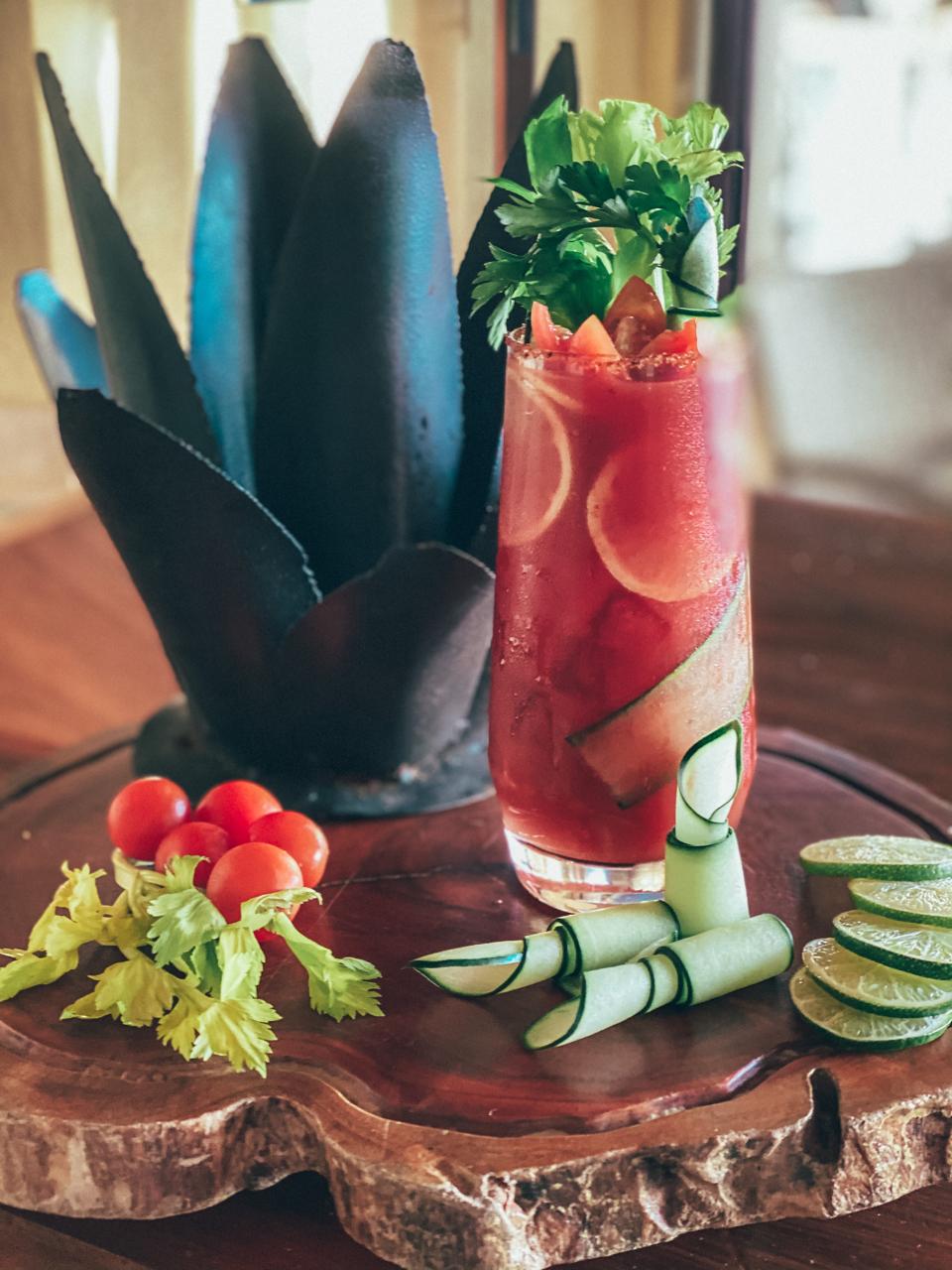 Tall Bloody Mary garnished with lots of fresh vegetables and citrus.