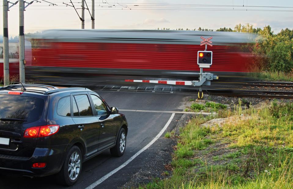 Red train passing through a railway crossing