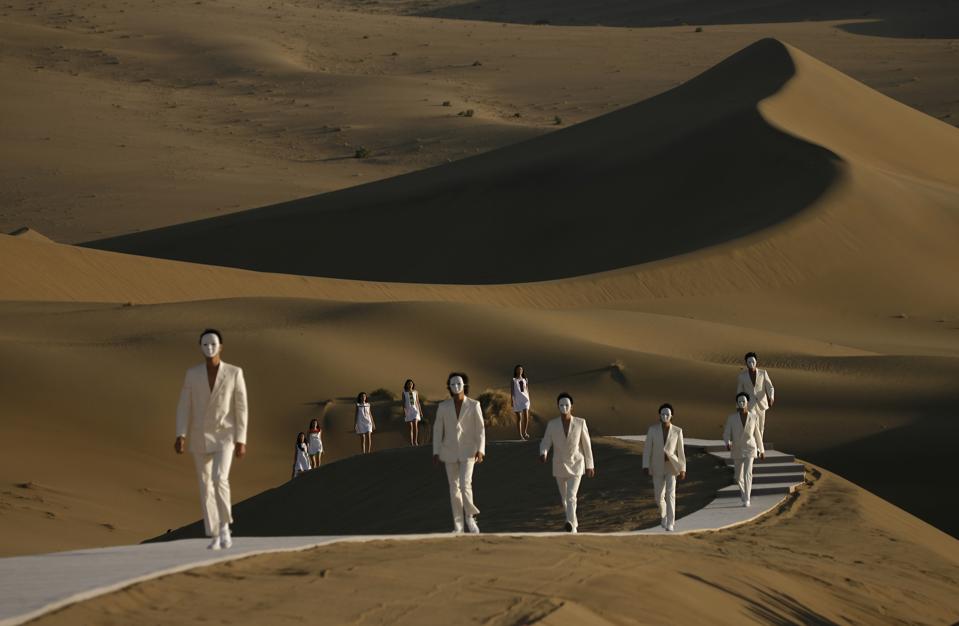 Models parade on a catwalk in the desert