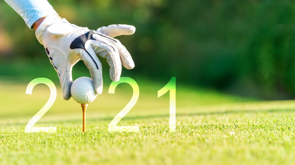 Golfer places ball on tee that forms the 0 in 2021