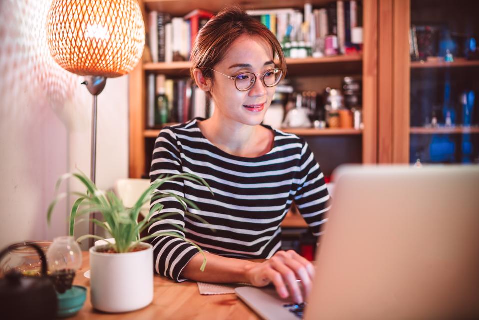 Young Asian woman working on a laptop computer at home