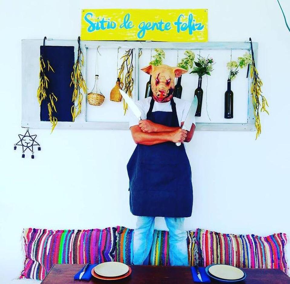 The chef of restaurant Sitio de Gente Feliz in Lisbon wears a pig mask in the dining room