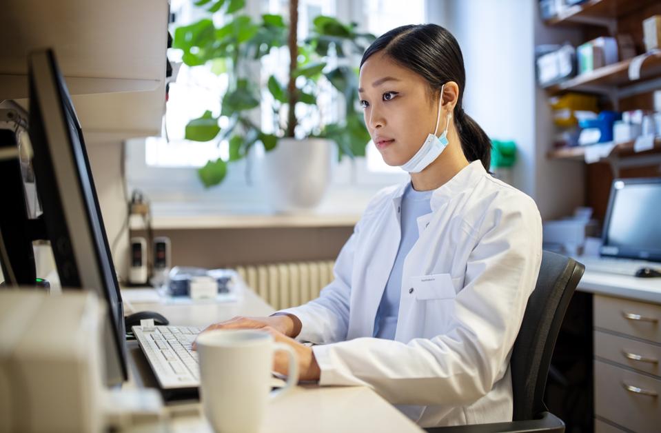 Woman working on computer at pharmacy lab