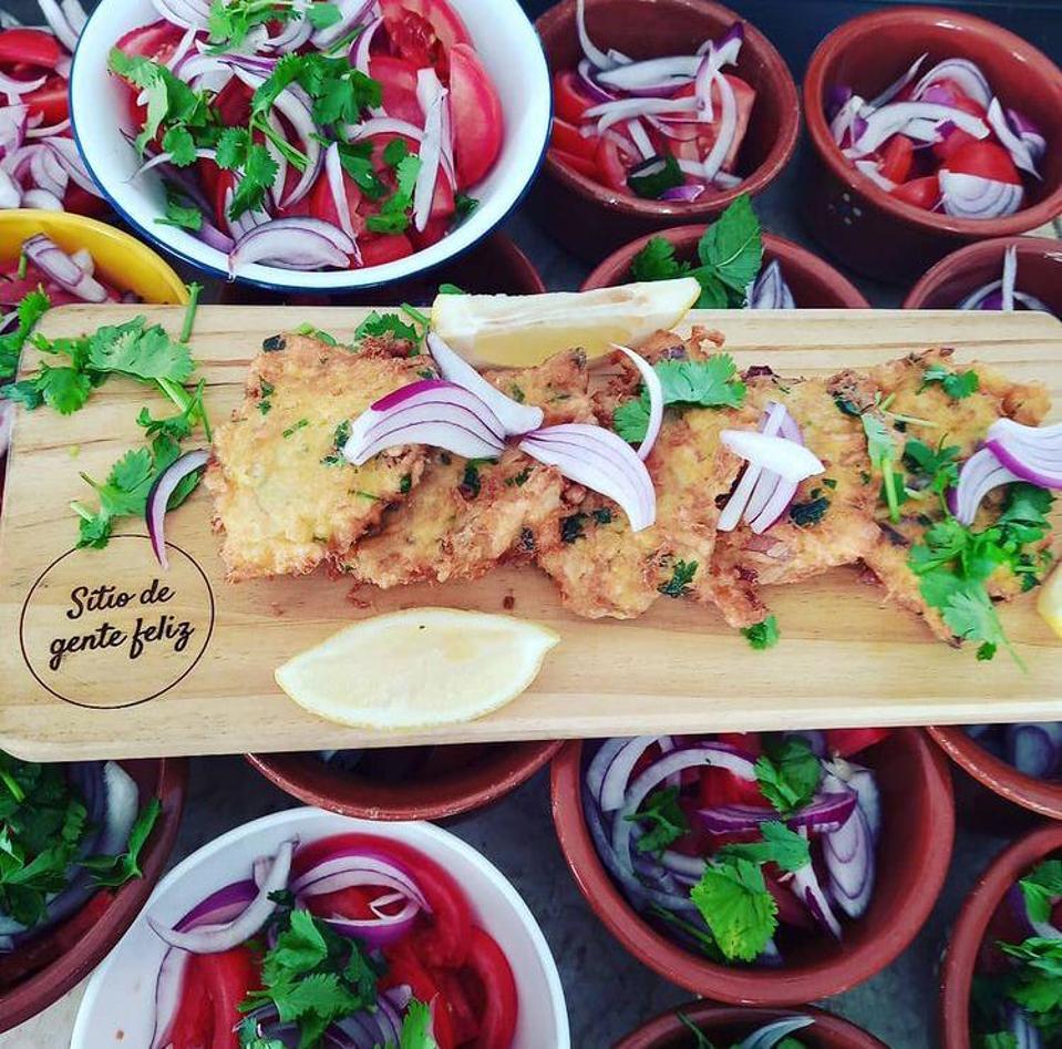Pataniscas and salads are arranged on a table at Sitio de Gente Feliz in Lisbon Portugal