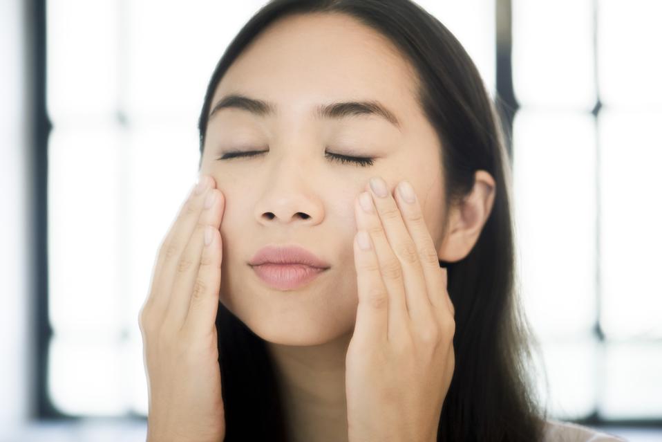 Woman touching her face, eyes closed