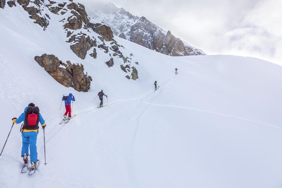 Group of people skiing in deep snow - ski tour, backcountry ski