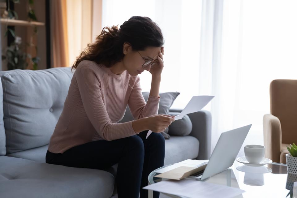 Frustrated desperate young woman reading refusal document.