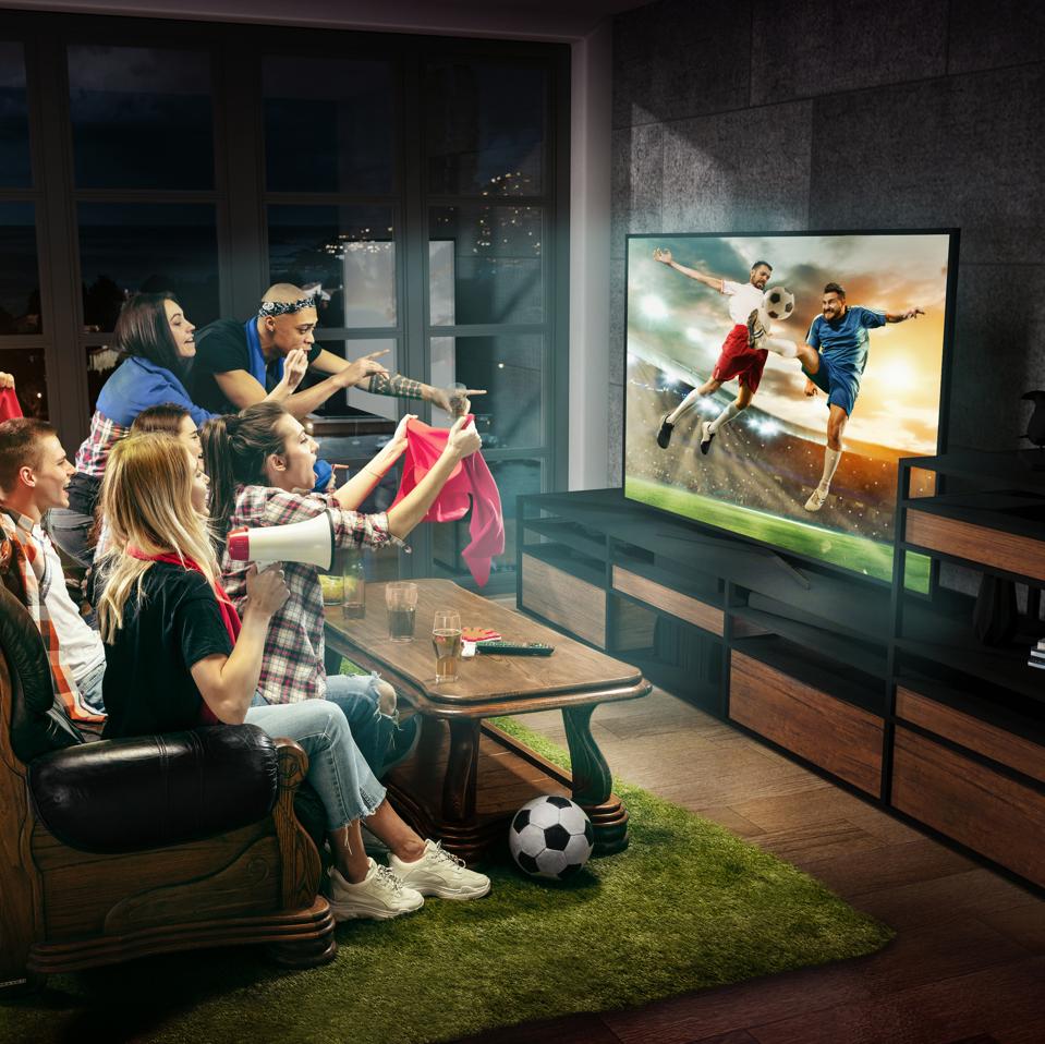 People loving watching sports on TV with their friends and family.