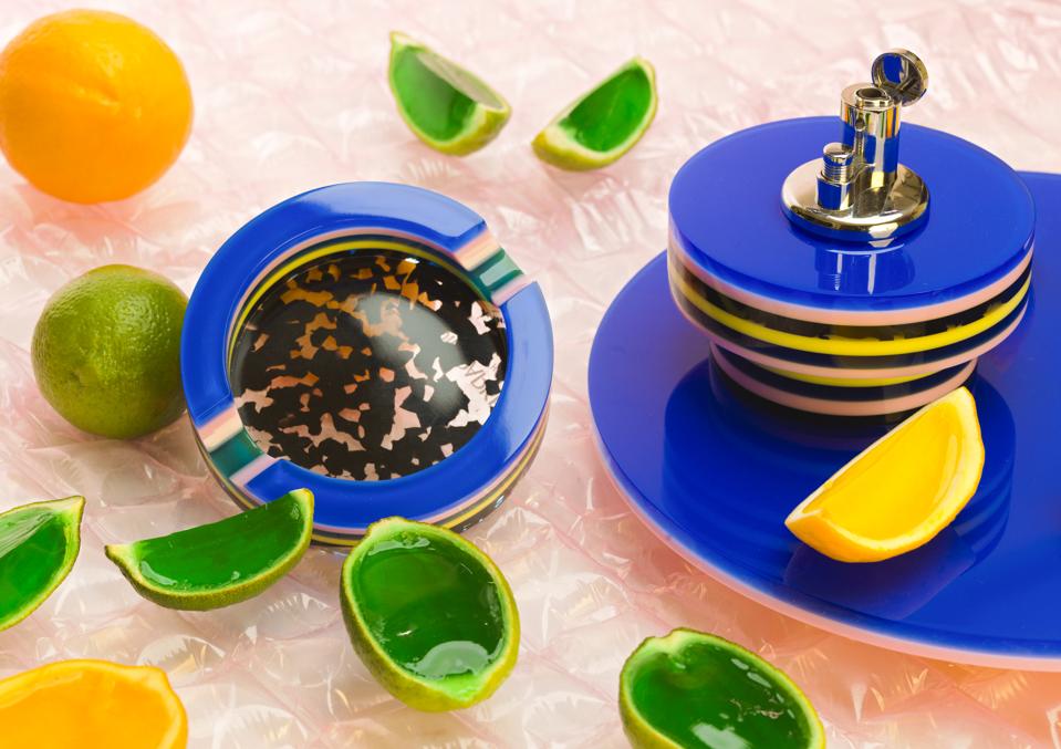A colorful tabletop lighter and ashtray set.