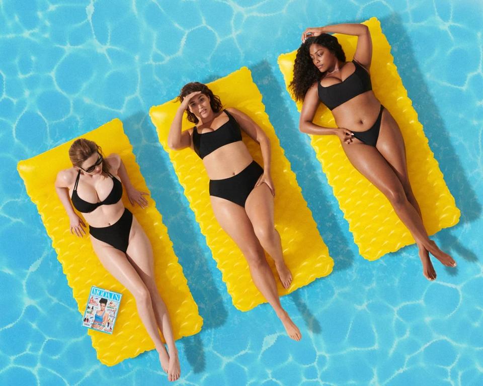 drie vrouwen op zwembaden in zwarte bikini ' s.