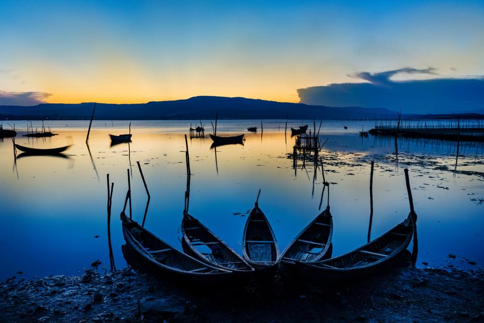 canoes on a glassy lake at sunset