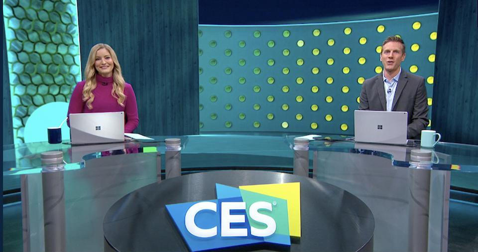 CES 2021 Anchor Desk hosts YouTuber Justine Ezarik (seated in a purple sweater) and KTLA's Rich DeMuro (seated in a grey jacket blue shirt).