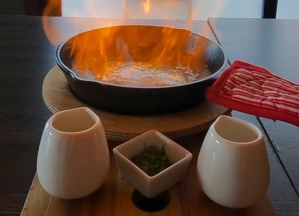 Close up of Flaming Fried Cheese being fired up in a cast iron skillet