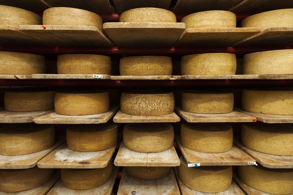 Les roues de fromage au lait de vache cru vieillissent à la crémerie.