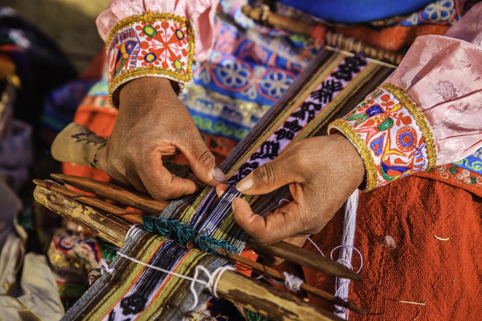 Close up of a Peruvian woman weaving textiles near Colca Canyon, Peru