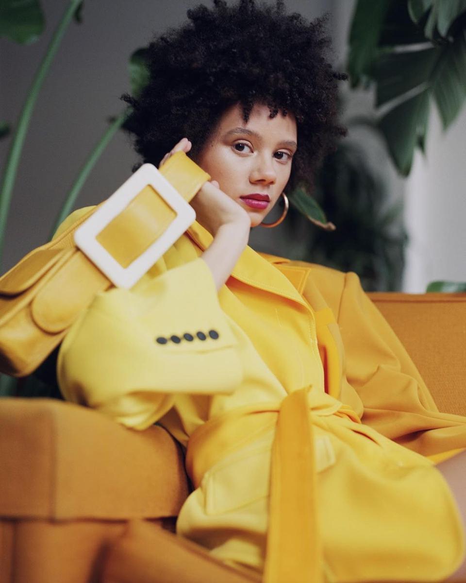 Edas model in yellow siky blazer coat with yellow Edas bag with large white buckle.