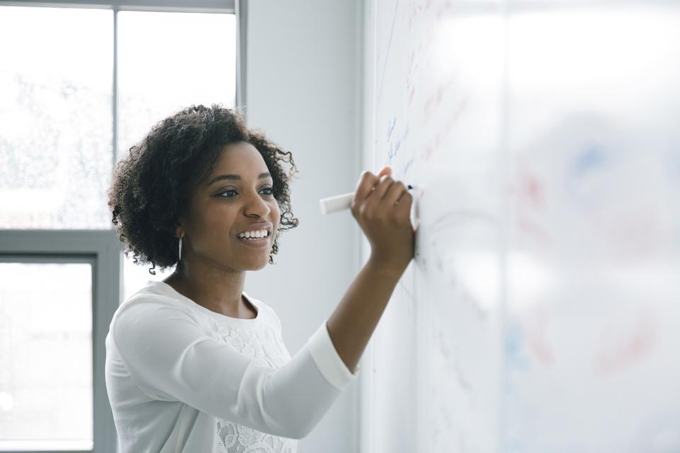 How To Create A Memorable Brand Persona 2 African American businesswoman writing on whiteboard in meeting