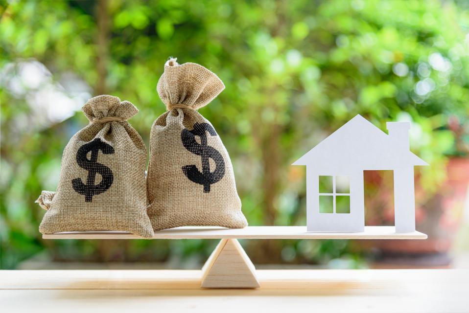 home loans, mortgage, house and money bags on a balance beam.