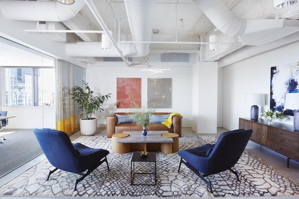office waiting room with blue chairs and exposed pipes