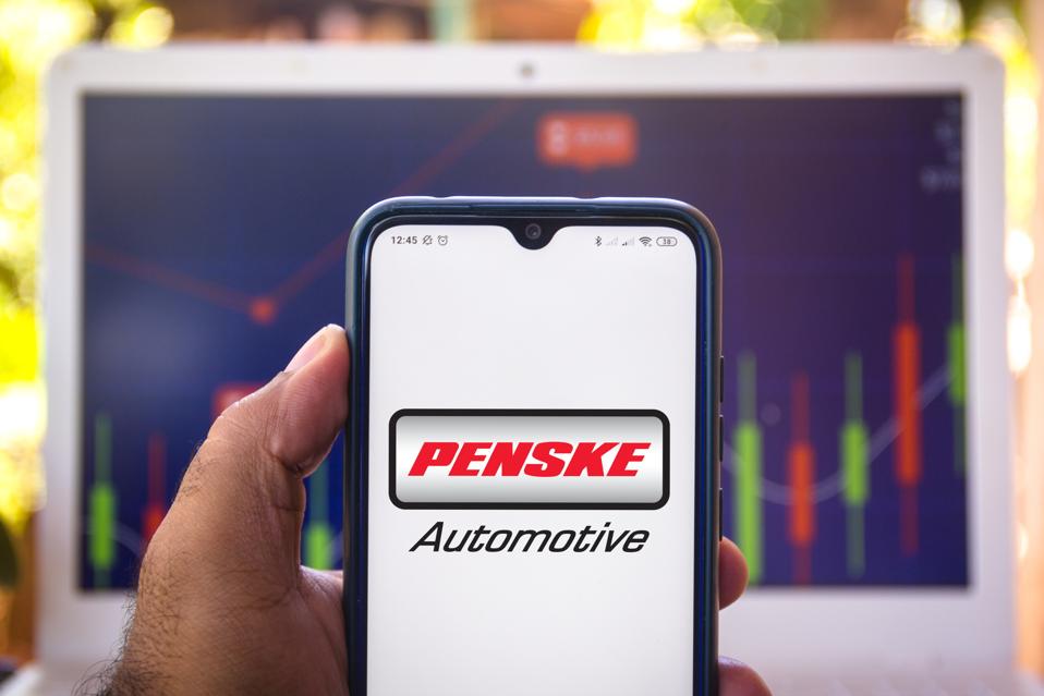 In this photo illustration the Penske Automotive Group logo...