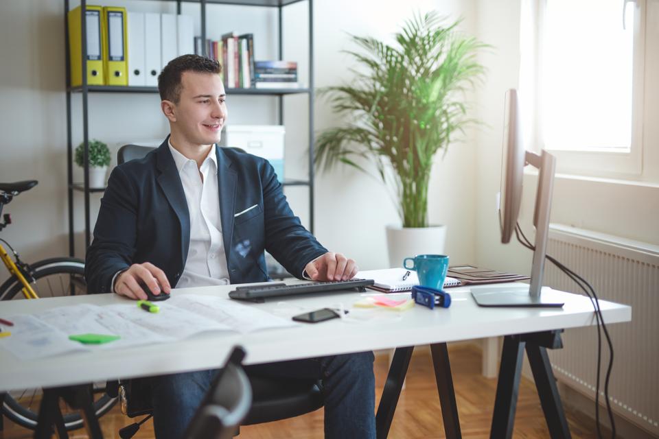 Cheerful businessman working on his computer