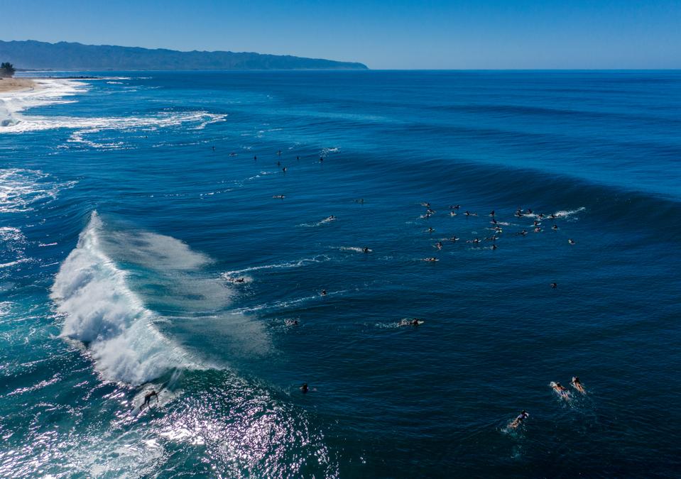Many surfers in the water at Banzai Pipeline beach on North Shore of Oahu