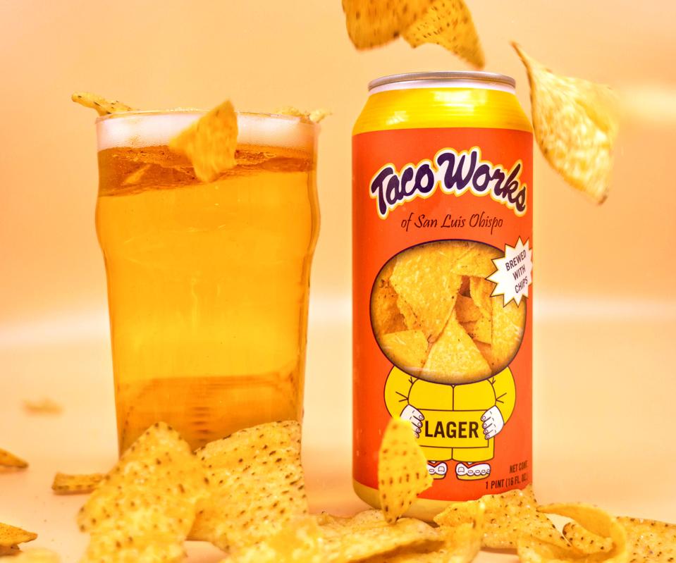 A can of beer, a glass of beer and a bunch of tortilla chips