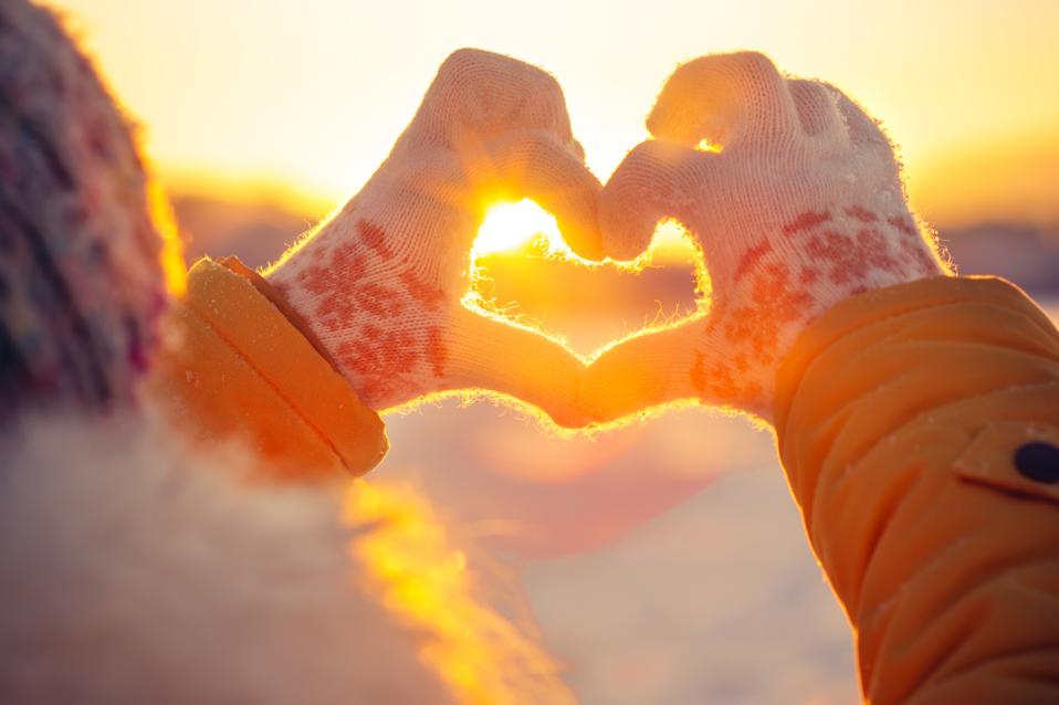 Woman hands in winter gloves Heart symbol