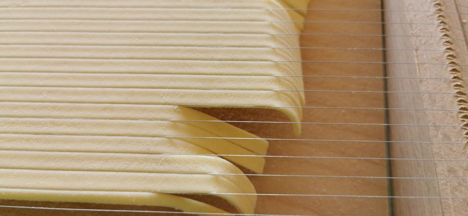 Pasta being cut on a Chitara