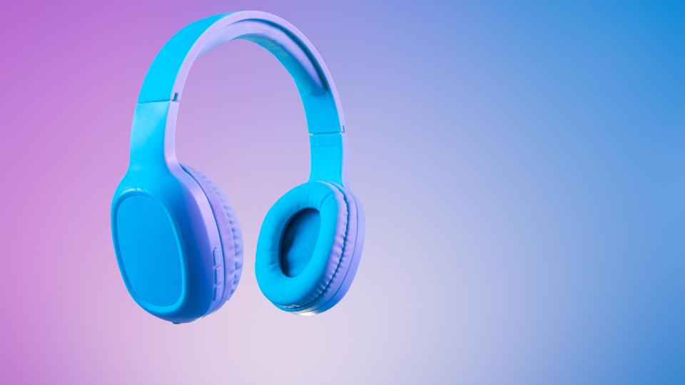Stylish blue headphones on multi colored / duo tone background lighting