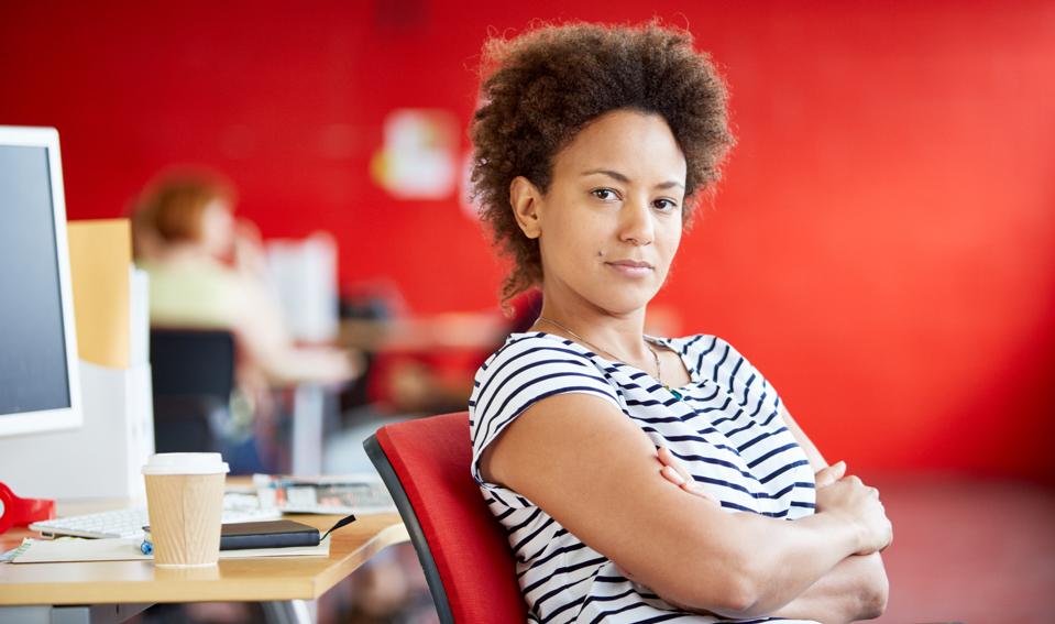 Confident female designer working in red creative office space
