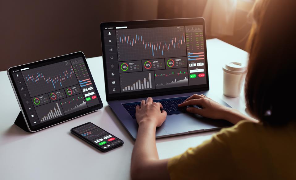 Woman looking at stock exchange market concept on laptop, tablet, and smartphone