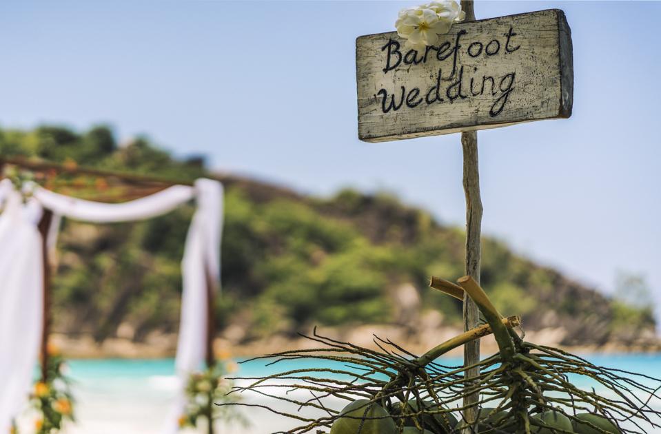 A sign on the beach in the Seychelles reads ″Barefoot Wedding″