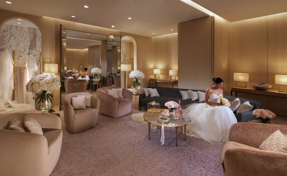 A bride in a white dress sits in a hotel suite at the Four Seasons Kuwait