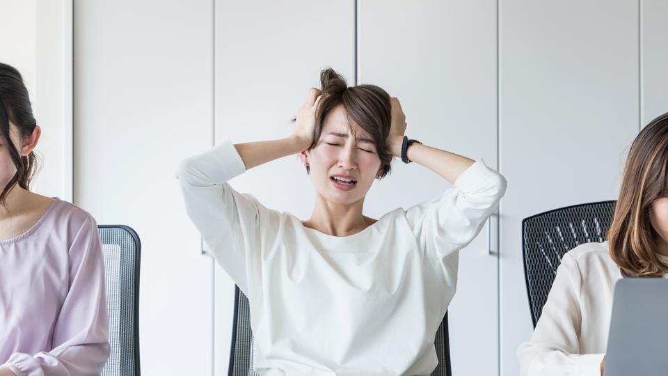 Young woman holding her head.
