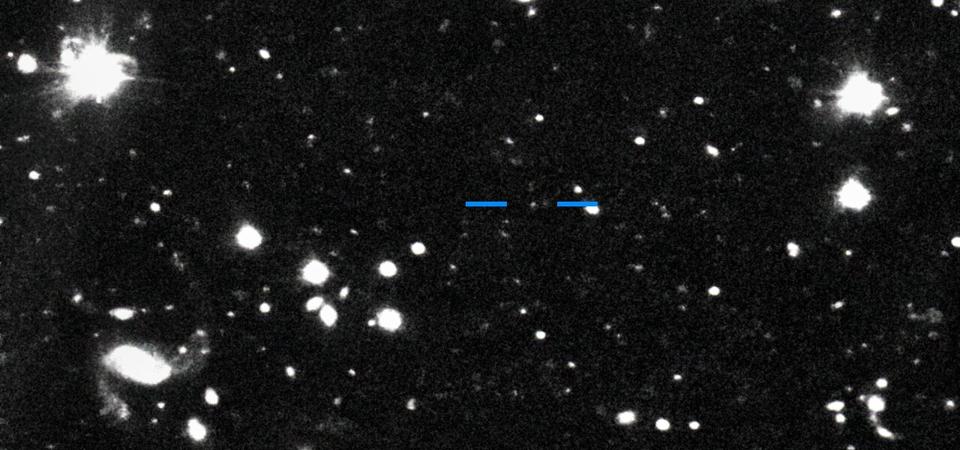 This discovery image of Farfarout (2018 AG37) was taken with the Subaru Telescope on the night of 16 January 2018 Universal Time (UT). By comparing this image with one taken on the previous night, it is possible to see that Farfarout (marked by blue horizontal lines) moves while the background stars and galaxies do not.